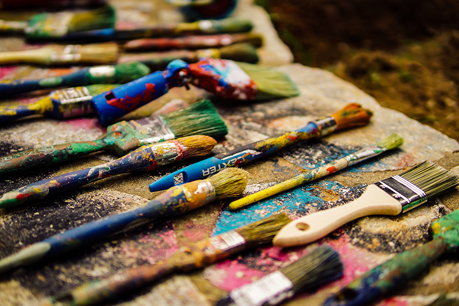 Paint brushes covered in various paints