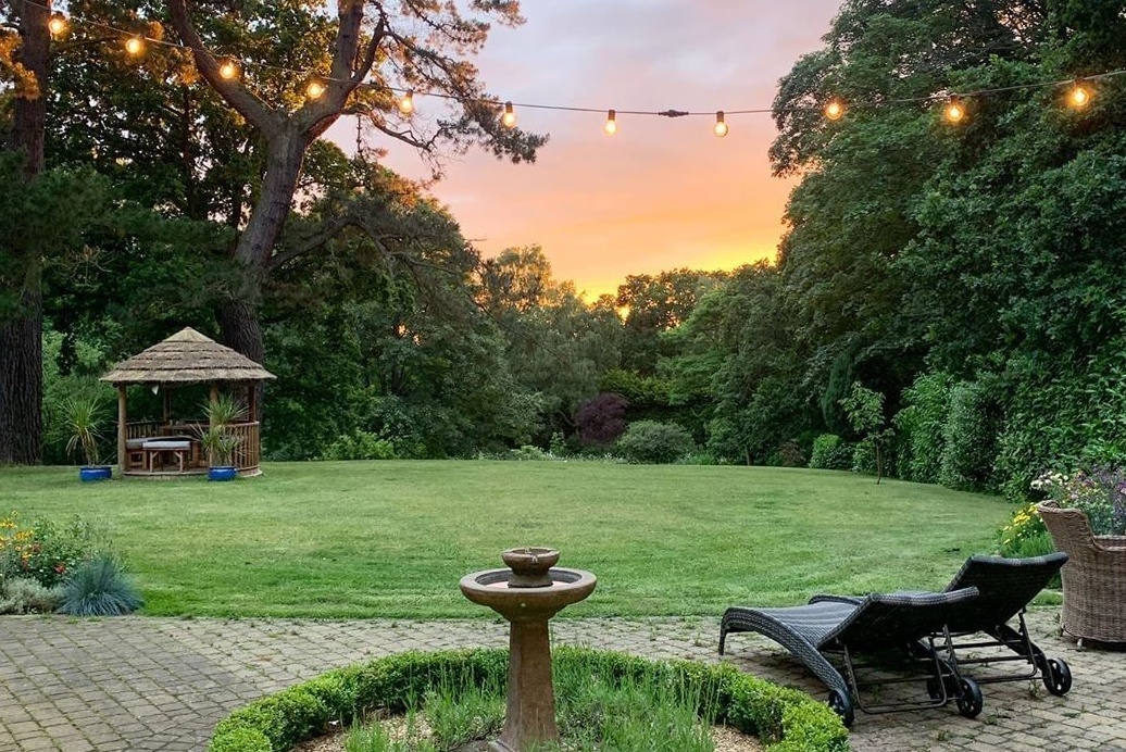 Garden at sunset with two sun loungers and a Breeze House garden gazebo in the background
