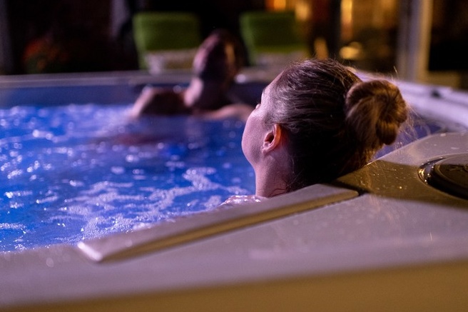 Couple reposing in a hydrofoil hot tub at night