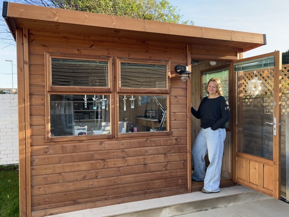 Ellen Hooper, founder of online silver and gemstone jewellery business Deviant Graceful at the door to her garden workshop