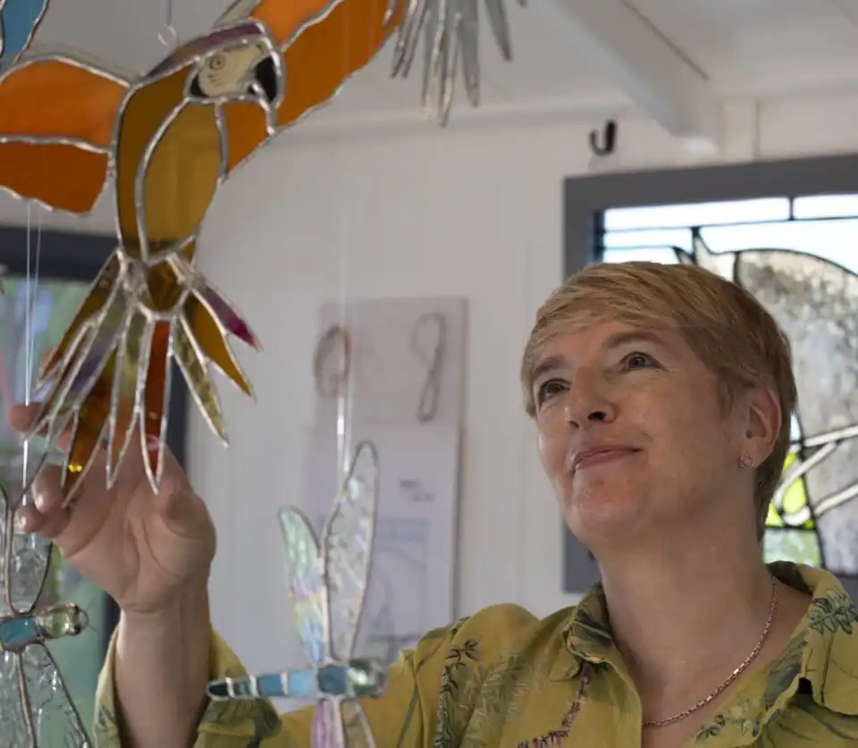 Sarah Davis of Sarah Davis Glass looking at hanging stained glass design