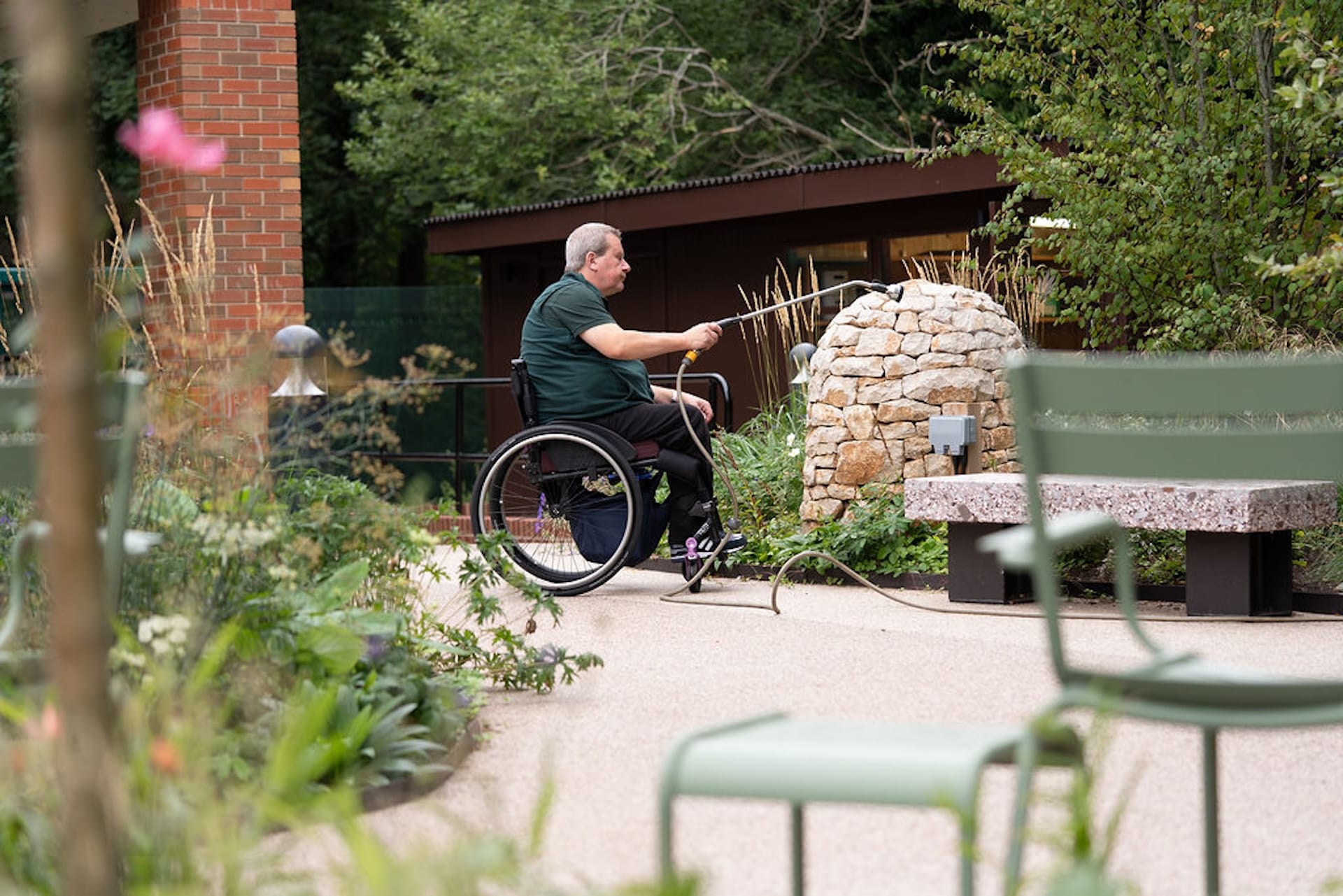 john watering flower bed inside horatios garden
